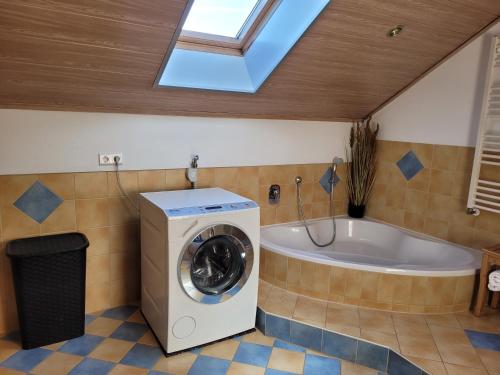 基尔夏姆Rudis Ferienwohnung的一间带洗衣机和浴缸的浴室