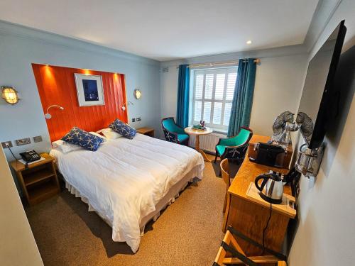 霍斯金丝特里克旅馆的卧室配有一张床和一张桌子及椅子