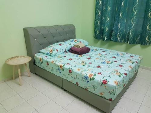汝来Damai Eco Homestay Nilai Negeri Sembilan的一间卧室配有一张带花卉棉被的床