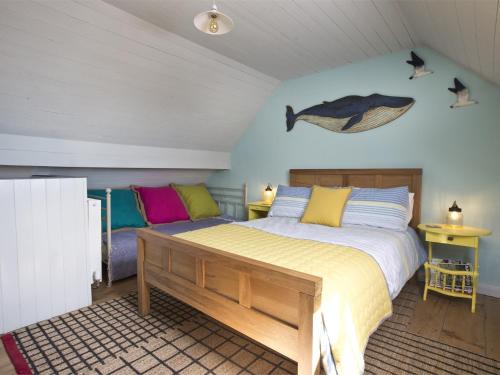 罗宾胡兹贝2 Bed in Robin Hoods Bay G0085的卧室配有一张床,墙上有一条鱼