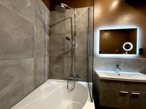 里加Dzelzavas Residence的带淋浴、浴缸和盥洗盆的浴室