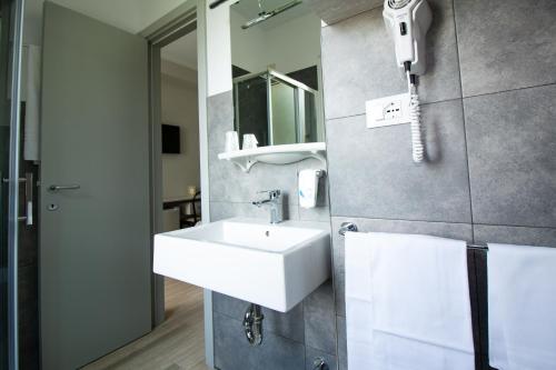 泰尔莫利欧罗巴酒店的一间带水槽的浴室和墙上的一部电话