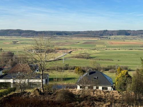 BourglinsterGîte des Hurlevents的享有田野的房屋和树木景致
