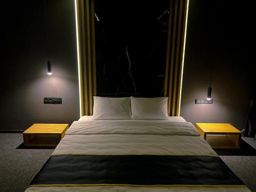 阿拉木图Atlas Hotel的一间卧室配有一张大床和两张桌子