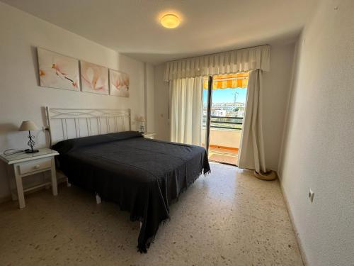 马塔拉斯卡尼亚斯bonito apartamento matalascañas的一间卧室设有一张床和一个阳台的窗户。