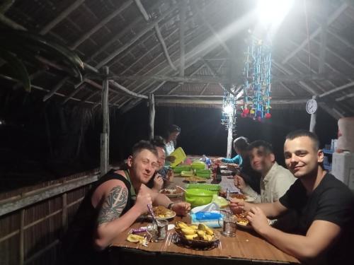 KriRansiwor Homestay的一群坐在餐桌上吃食物的人