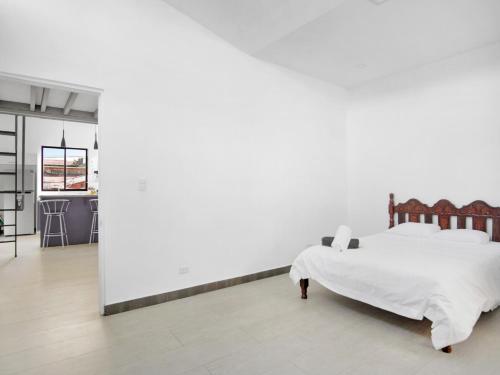 圣何塞Casa Bellavista Suites的一间卧室设有一张床和白色的墙壁