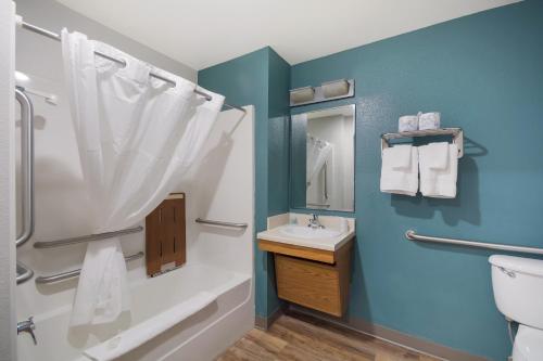 格林维尔WoodSpring Suites Greenville Central I-85的带淋浴、盥洗盆和卫生间的浴室
