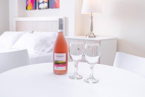 利马Residencial Suiza的桌子上放有一瓶葡萄酒和两杯酒