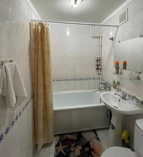 塔尔迪库尔干Меломан的带浴缸、卫生间和盥洗盆的浴室