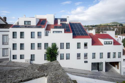 蓬塔德尔加达Alto do Forte的屋顶上设有太阳能电池板的白色建筑