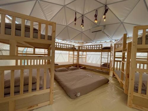 Tân PhúTropical eGlamping的帐篷内带三张双层床的房间