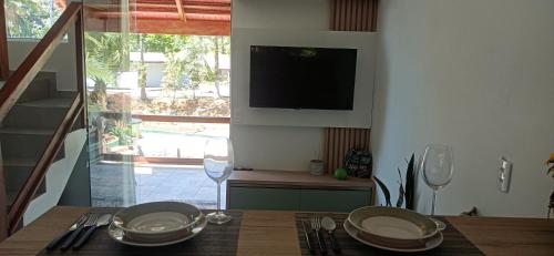 南雅拉瓜Chalé Girassol的厨房配有桌子,墙上配有电视