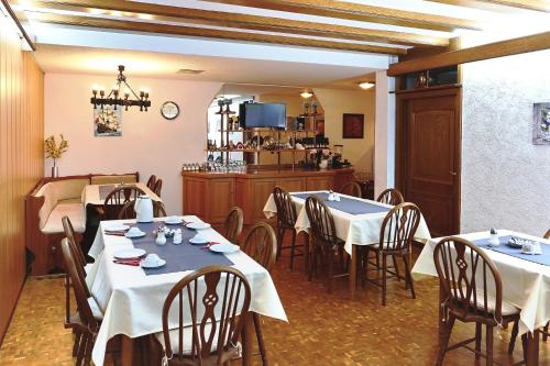 KirrweilerHotel Garni Sebastian的一间带2张桌子和椅子的餐厅以及一间厨房