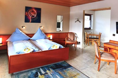 KirrweilerHotel Garni Sebastian的一间卧室配有一张带蓝色枕头的床和一张书桌