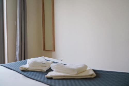 蒙蒂茹Always on the way - Road Home in Montijo, Lisbon的两条毛巾坐在房间里的床边