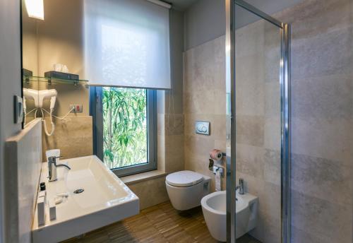 瓦斯托ALKIMIA boutique hotel的一间带水槽和卫生间的浴室以及窗户。