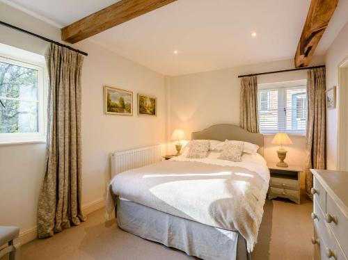 米德赫斯特2 Bed in Midhurst 88938的一间卧室设有一张床和两个窗户。