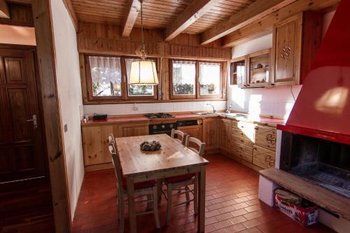 克雷亚佐App Carolina的厨房配有木制橱柜、桌子和炉灶。