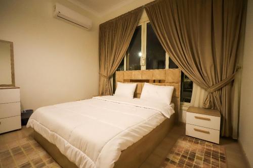十月六日城Villa X15-11 Grand Heights的卧室配有一张大白色床和窗户