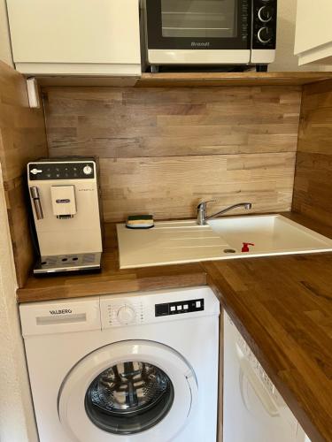 乐巴凯尔斯Studio cabine barcares的厨房配有洗衣机和微波炉。