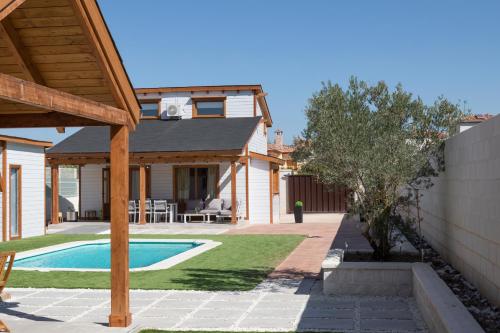 昆卡Luxury Rural Cuenca的一个带游泳池和房子的后院