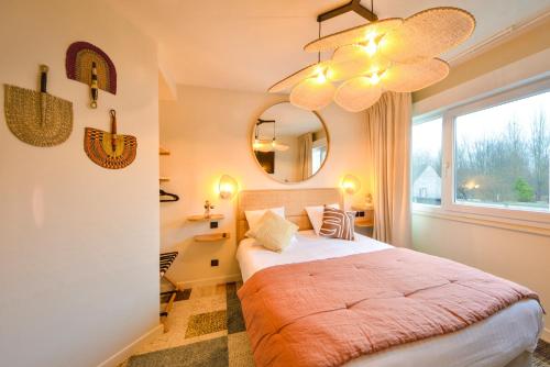 布尔日B Hôtel Olympia Bourges - Chambres rénovées fin 2023 -的一间卧室配有一张带镜子的床和窗户