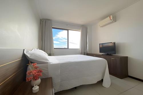 拉巴拉德纳圣米格尔Barra Bali: Resort Beira Mar的卧室配有白色的床和电视。