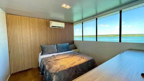 巴西利亚WTS HOUSE BOAT的一间卧室设有一张床和一个大窗户