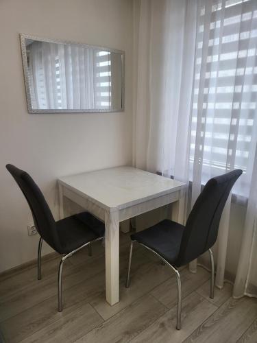 华沙Krucza Apartament的一张带两把椅子和镜子的白色桌子