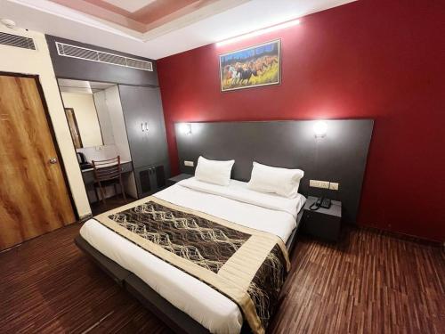 新德里Hotel Diamond Airport的一间卧室设有一张红色墙壁的大床
