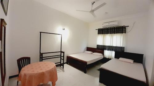 波隆纳鲁沃Hotel Sanhida Polonnaruwa的客房设有两张床、一张桌子和镜子