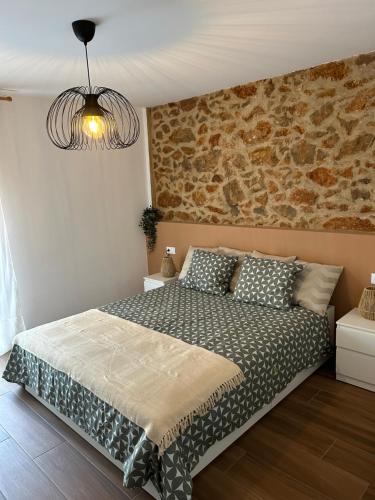 卡瓦内斯Casa Juan的一间卧室设有一张床和石墙