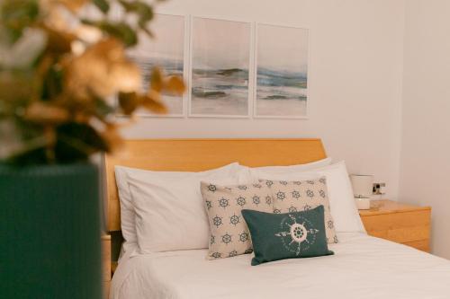 比尔古Grand Harbour View的一间卧室配有带白色床单和枕头的床。