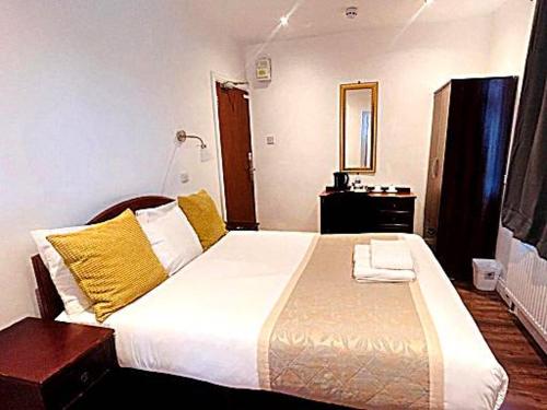 达格纳姆BA TRADERS的一间卧室配有一张带黄色枕头的大床