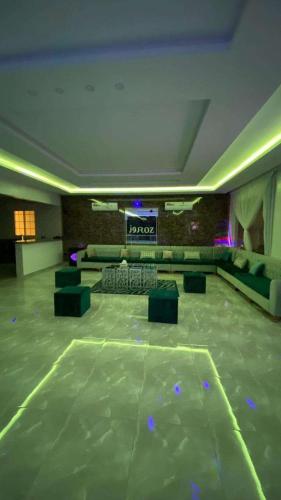 Ad Dihāsīyahفله روز的客厅,配有沙发和舞台,位于大楼内