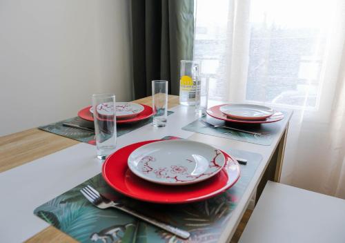 讷伊-普莱桑斯Cosy Casa entre Paris et Disney的红白板和玻璃杯桌子