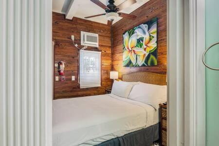 基韦斯特Coral Cove #1 by Brightwild的卧室配有一张床,墙上挂有绘画作品