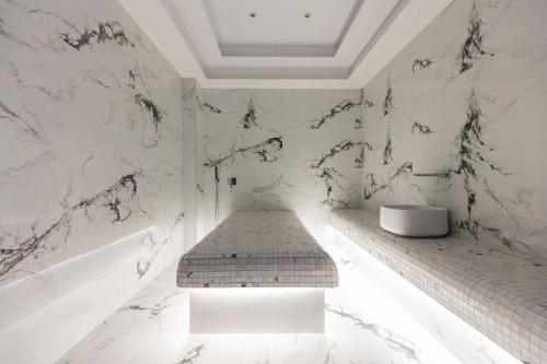 地拉那Destiny Hotel & SPA的白色的浴室设有长凳和水槽