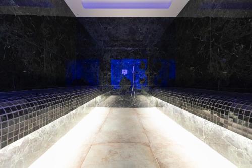 地拉那Destiny Hotel & SPA的黑暗的房间,有水池和灯光
