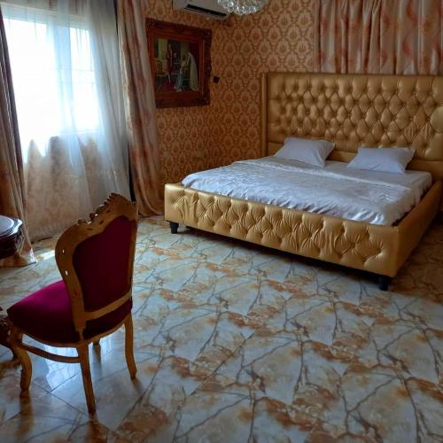 莱基Grand Emperor Museum Hotels and Resorts的一间卧室配有一张特大号床和一把椅子