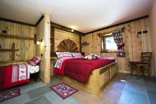 尚波吕克罗日特斯吉昂公寓的卧室配有一张床铺,位于带木墙的房间内