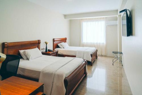 瓜亚基尔马尔奇丽斯酒店的酒店客房设有两张床和窗户。