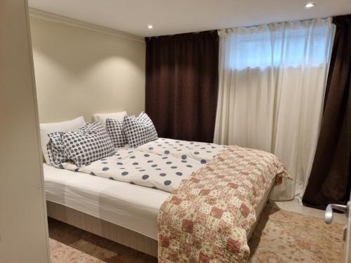 默恩达尔90 m2 charmig källarlägenhet nära natur och stad的卧室配有带枕头的床铺和窗户。