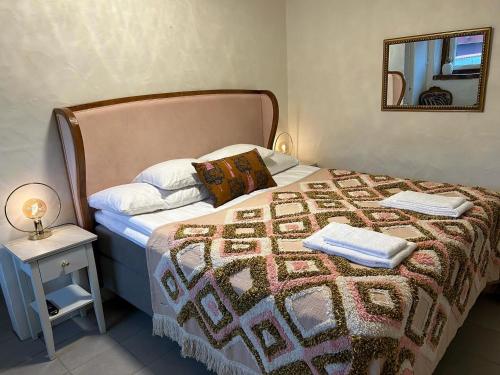 哈尔姆斯塔德Halmstad Gårdshotell的一间卧室配有一张带毯子和镜子的床