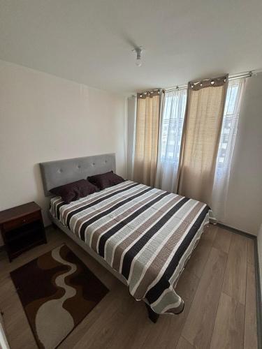 阿里卡Acogedor departamento arica的一间卧室配有带条纹毯子的床