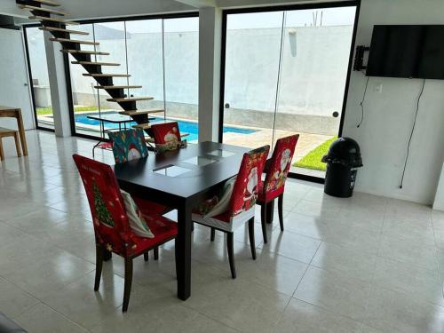 谢内吉亚区Casa de Campo Paz y Bien - Cieneguilla的一张带红色椅子的餐桌和楼梯