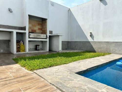 谢内吉亚区Casa de Campo Paz y Bien - Cieneguilla的庭院中带游泳池的房子