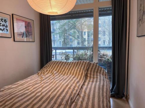 哥本哈根Central family home in award-winning architecture的一间卧室设有一张床和一个大窗户