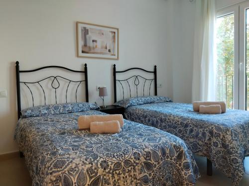 托雷帕切科Apartamento La Torre Golf的一间卧室设有两张床和窗户。